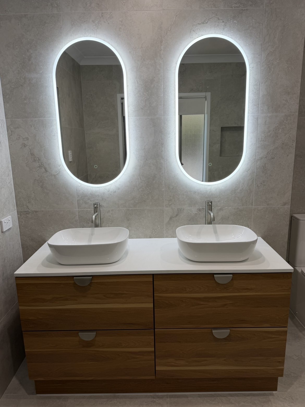 Bathroom renovation — double vanity, backlit LED oval mirrors